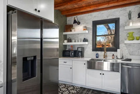 a kitchen with white cabinets and a refrigerator