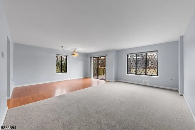 a view of a big room with windows and chandelier fan