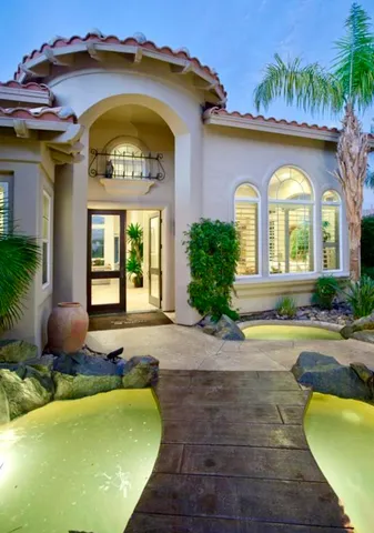 a view of a house with large windows and a small yard