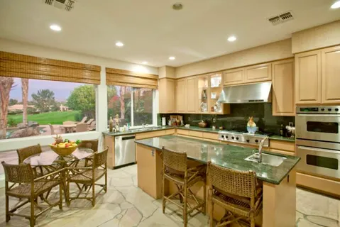 a kitchen with a table chairs stove and cabinets