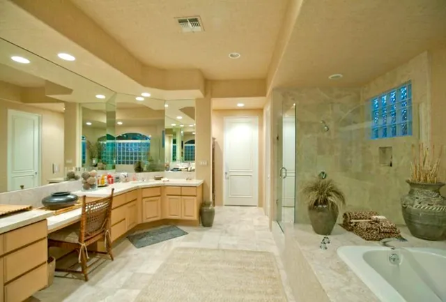a large bathroom with a sink mirror and a bath tub