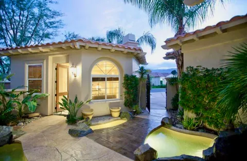a view of a house with swimming pool patio and a garden