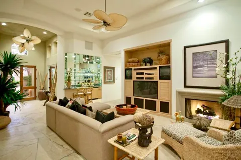a living room with furniture kitchen view and large windows