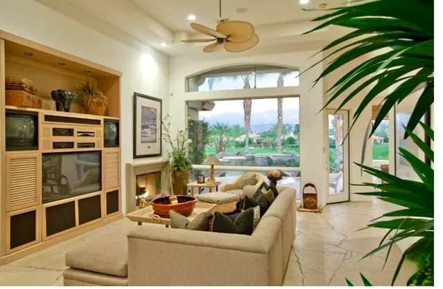 a living room with furniture fireplace and a large window