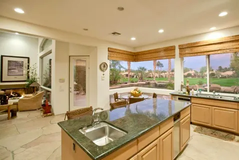 a kitchen with a large window and a view of living room