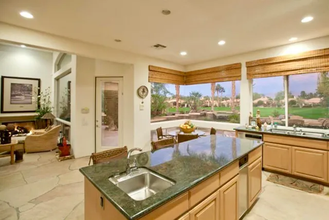 a kitchen with a large window and a view of living room