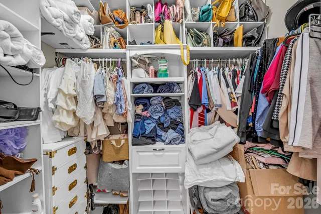 a view of walk in closet with clothes and shoes