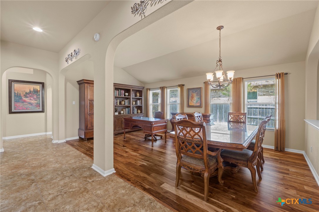 20525 Jackies Ranch Boulevard Pflugerville, TX 78660 - Photo 12 of 30 Dining space with arched walkways, wood finished floors, lofted ceiling, and a chandelier