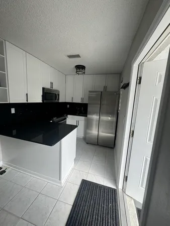 a kitchen with granite countertop stainless steel appliances a refrigerator a sink a stove a microwave and cabinets