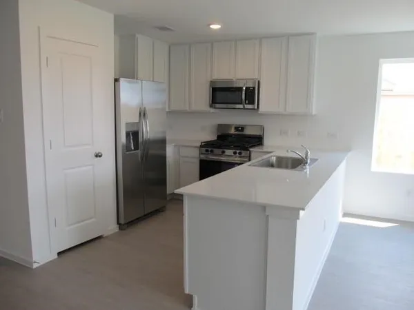 a kitchen with stainless steel appliances granite countertop a stove a sink and a refrigerator