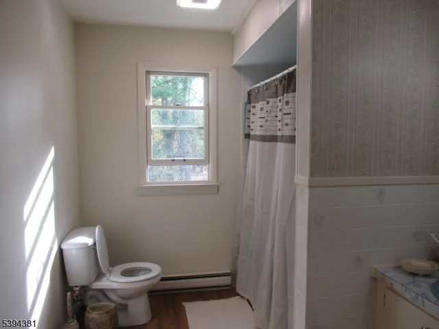 a bathroom with a toilet a sink and a window