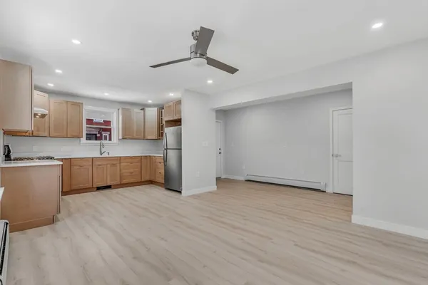 a large kitchen with stainless steel appliances granite countertop a stove a sink and a refrigerator