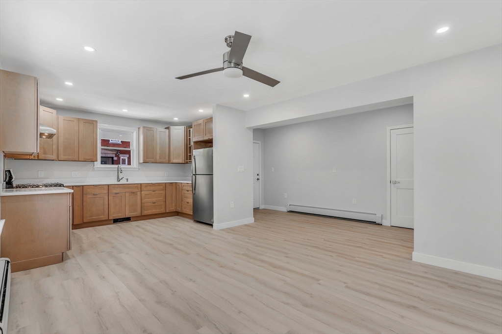 74 Ruthven Street, Unit 1 Boston, MA 02121 - Photo 3 of 11 a large kitchen with stainless steel appliances granite countertop a stove a sink and a refrigerator