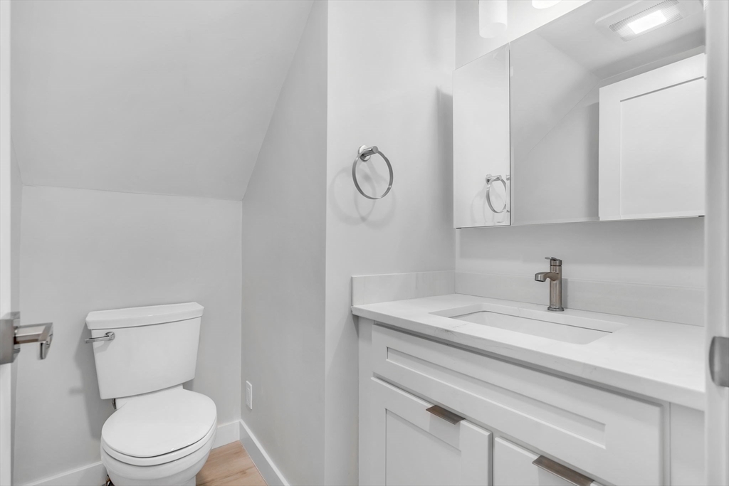 74 Ruthven Street, Unit 1 Boston, MA 02121 - Photo 4 of 11 a bathroom with a toilet a sink and mirror
