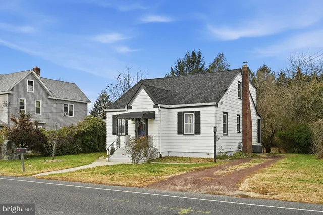 a view of a house with a yard and palm trees