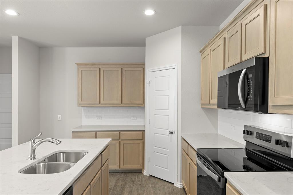 1713 Teton River Drive Blue Ridge, TX 75424 - Photo 11 of 29 a kitchen with stainless steel appliances a sink a stove a microwave a sink a refrigerator and cabinets
