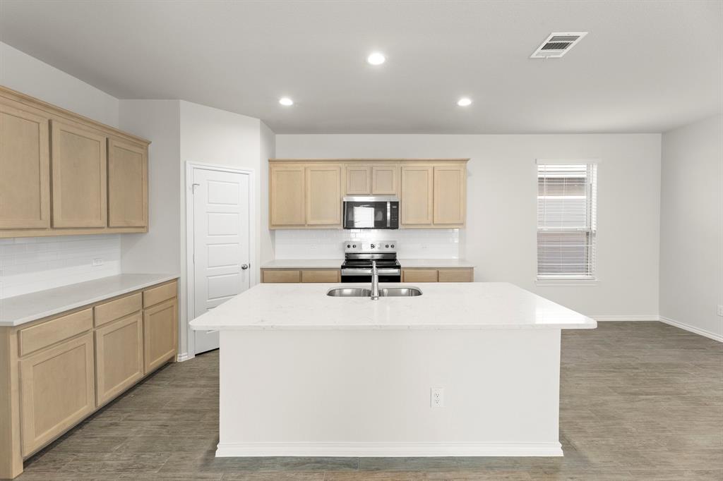 1713 Teton River Drive Blue Ridge, TX 75424 - Photo 9 of 29 a kitchen with kitchen island a sink a stove a refrigerator and white cabinets