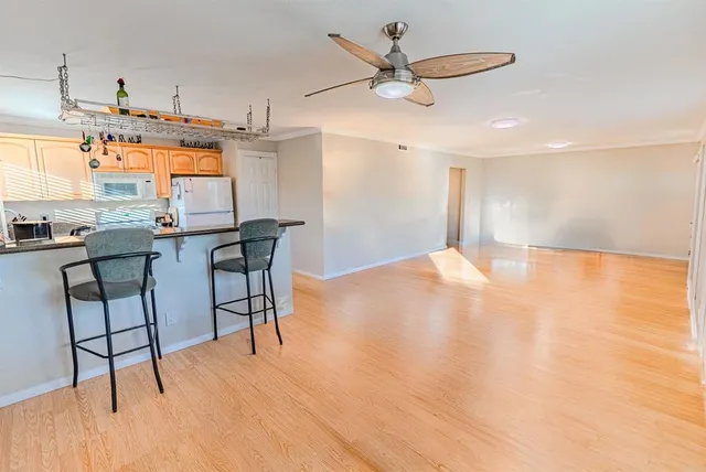 a view of a kitchen with stainless steel appliances wooden floor dining table and chairs