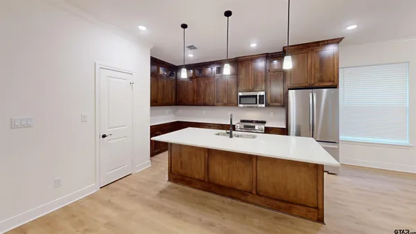a view of kitchen with a sink a refrigerator and wooden floor