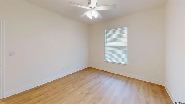 an empty room with a window and wooden floor