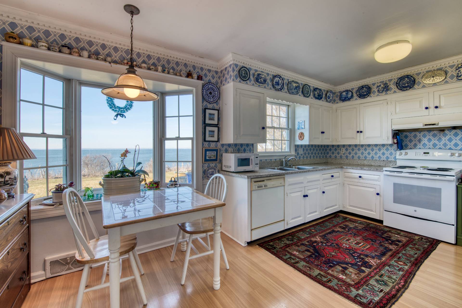 335 Sound View Road Orient, NY 11957 - Photo 16 of 22 a kitchen with a table chairs stove and cabinets