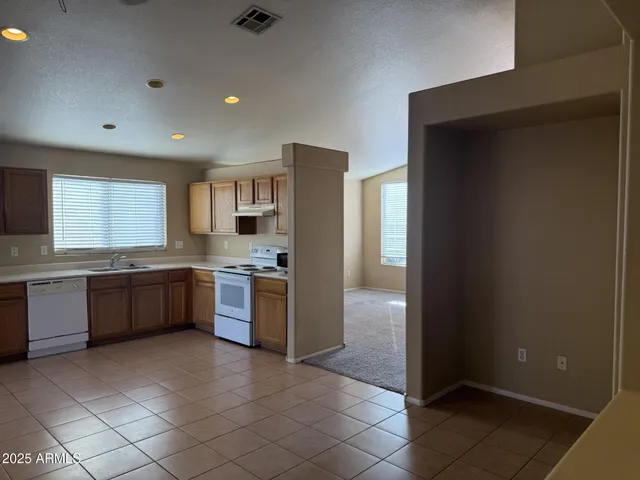 a large kitchen with a large counter top space a sink and stainless steel appliances