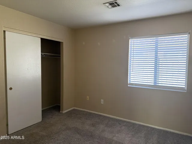 an empty room with a window and a ceiling fan