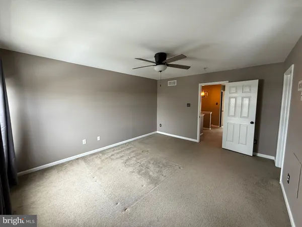 an empty room with a ceiling fan and a window