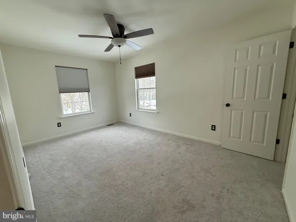 an empty room with windows and closet