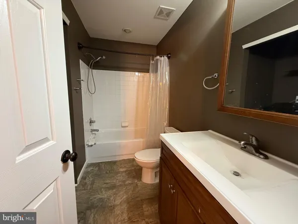 a bathroom with a sink a toilet a mirror and shower