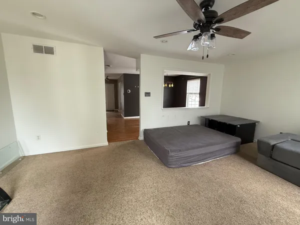 a living room with furniture and a ceiling fan