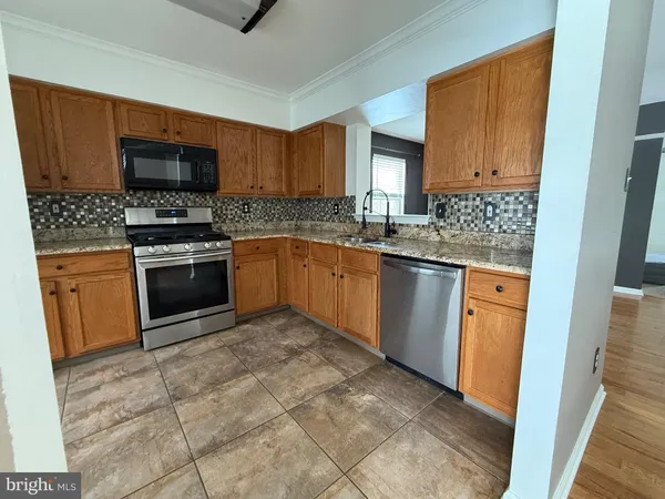 a kitchen with stainless steel appliances granite countertop a stove sink and microwave