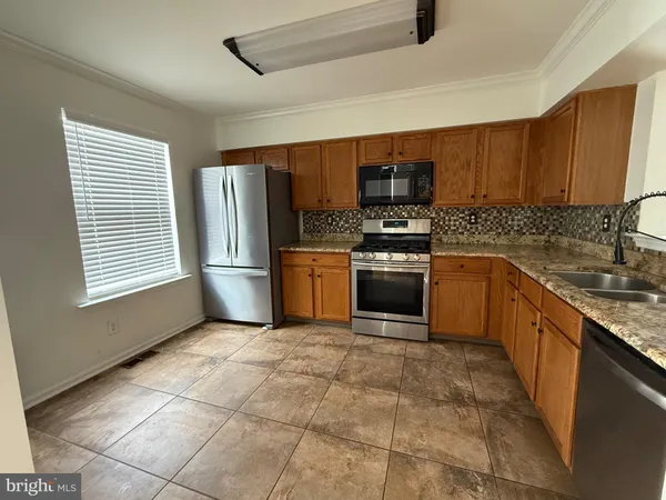 a kitchen with stainless steel appliances granite countertop a stove sink and cabinets