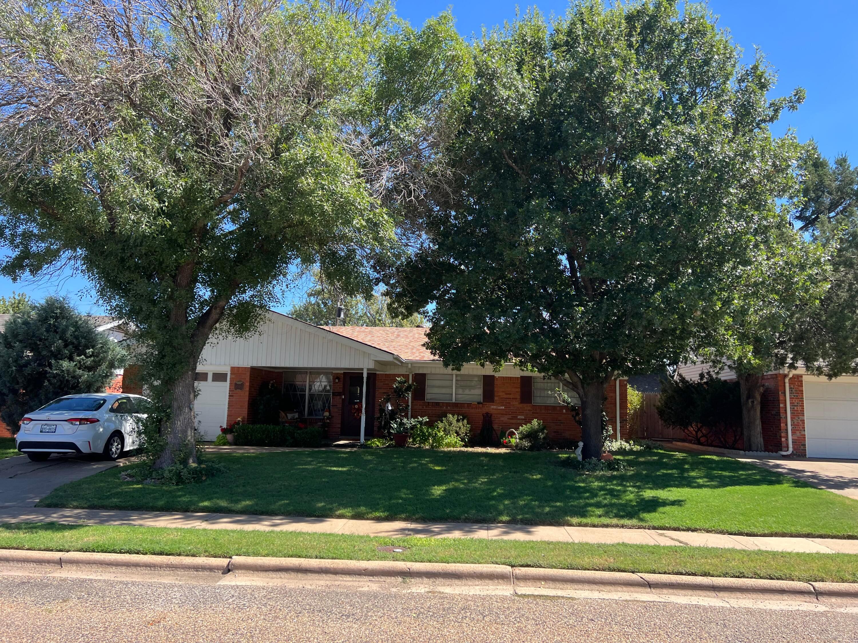 a front view of a house with a yard and a garage