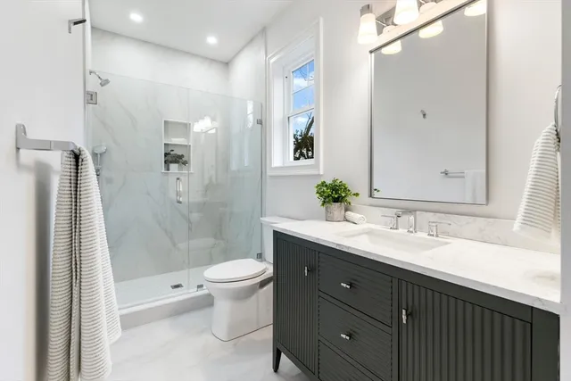 a bathroom with a sink a toilet and shower