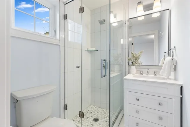 a bathroom with a sink a toilet and shower