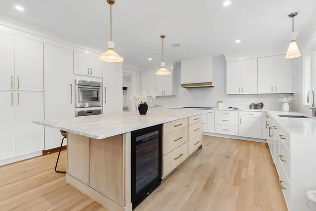 a kitchen with a sink a counter space appliances and cabinets