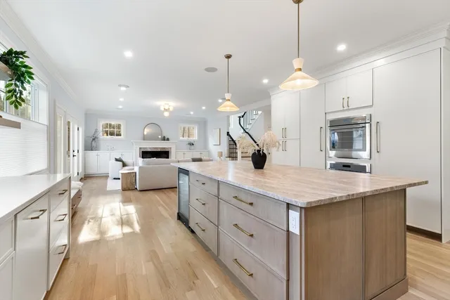 a large kitchen with kitchen island a stove a sink a refrigerator and a fireplace