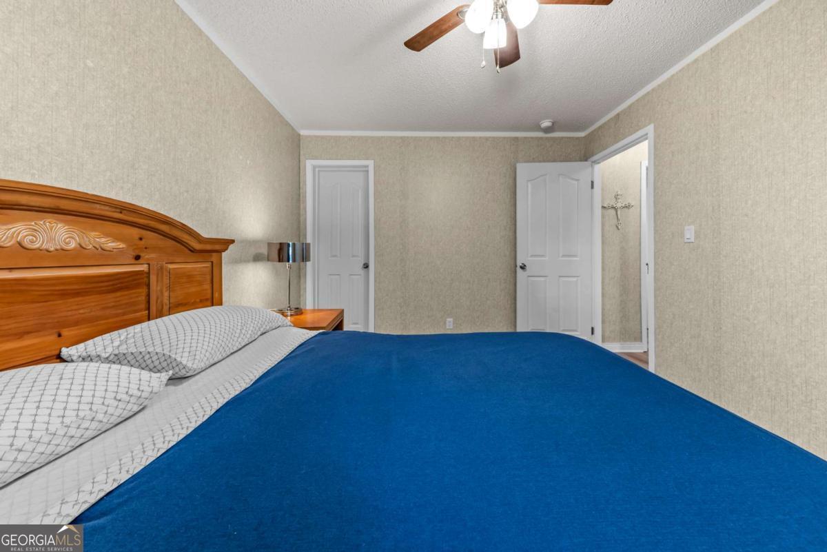 194 Phillips Road Eatonton, GA 31024 - Photo 31 of 57 a bedroom with a bed and a chandelier