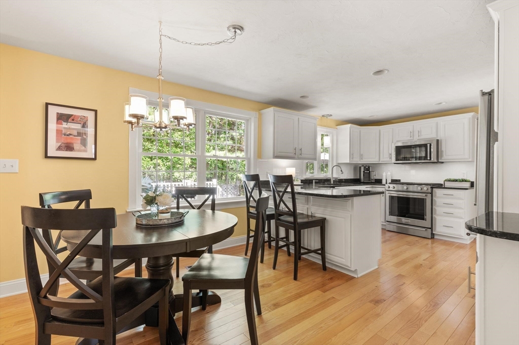67 Bridle Path Franklin, MA 02038 - Photo 6 of 35 a open dining room with stainless steel appliances kitchen island granite countertop a dining table chairs and a microwave