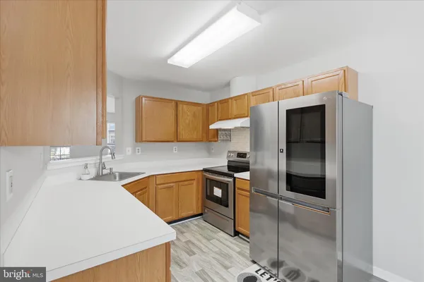 a kitchen with stainless steel appliances granite countertop a refrigerator and a sink