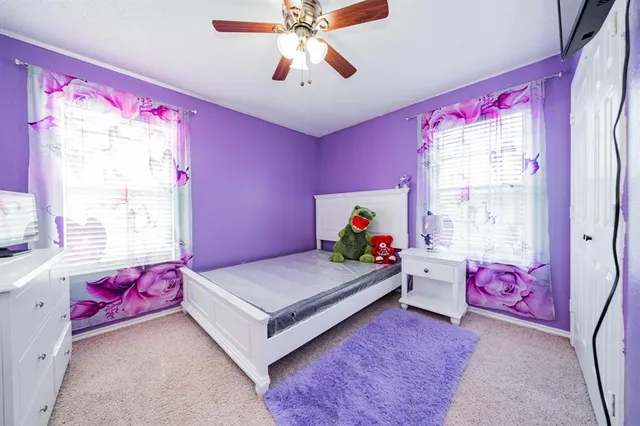 a bedroom with pink walls a bed and a window
