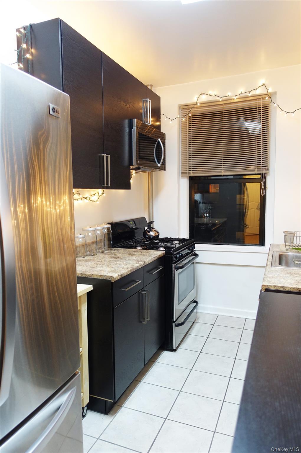 62-64 Saunders Street, Unit 4P Queens, NY 11374 - Photo 5 of 9 a kitchen with stainless steel appliances granite countertop a refrigerator and a stove