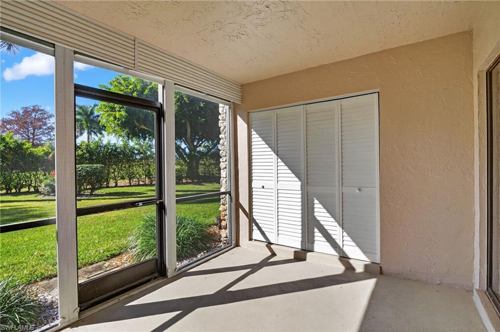 5773 Gage Lane, Unit B101 Naples, FL 34113 - Photo 17 of 39 a view of a room with a large window and wooden floor