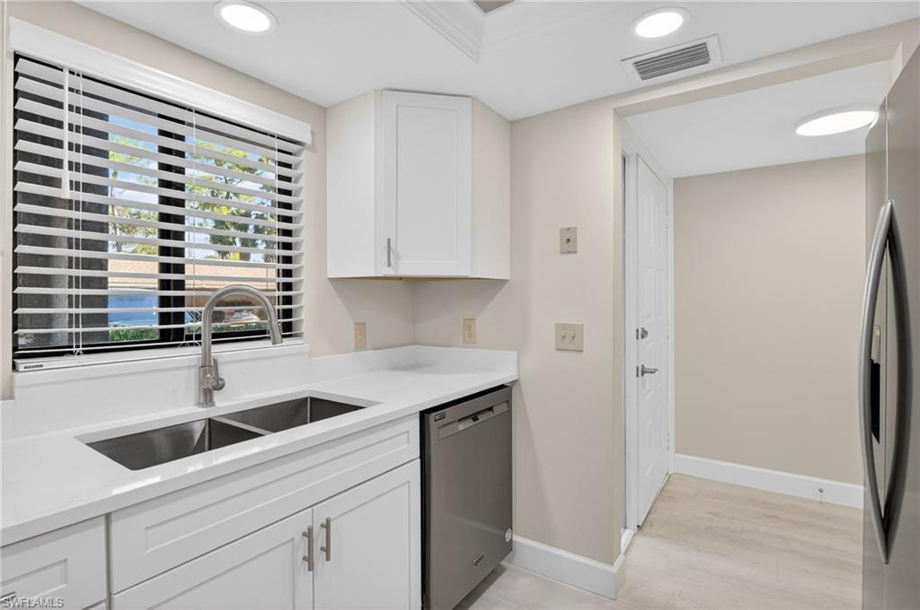 5773 Gage Lane, Unit B101 Naples, FL 34113 - Photo 9 of 39 a kitchen with a sink and cabinets