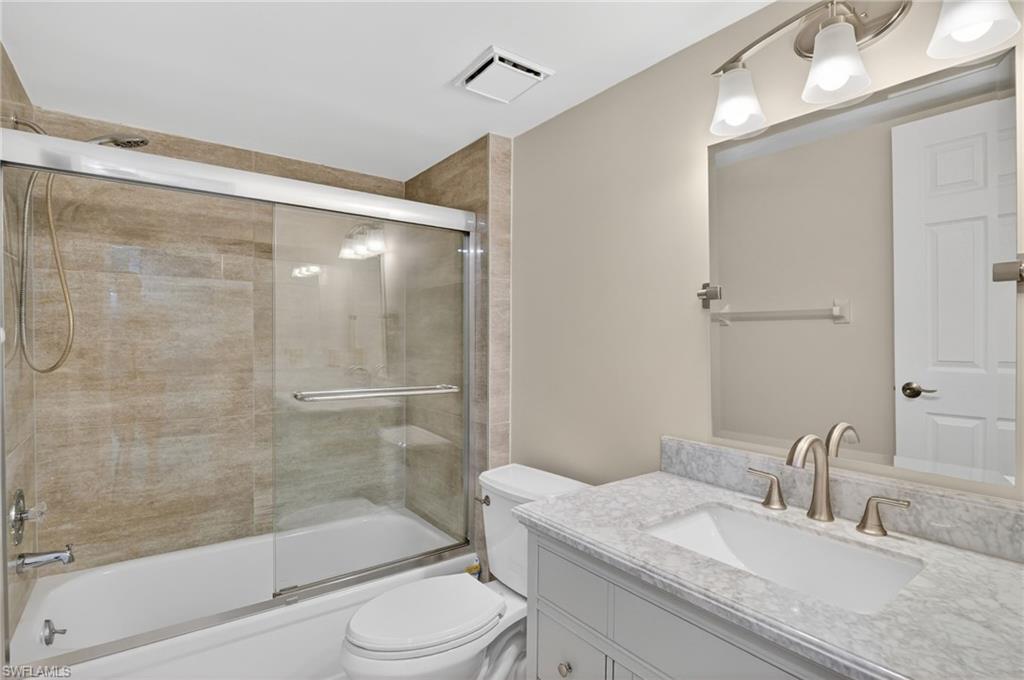 5773 Gage Lane, Unit B101 Naples, FL 34113 - Photo 10 of 39 a bathroom with a granite countertop bathtub shower sink vanity and toilet
