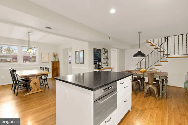a kitchen with stainless steel appliances granite countertop a table and chairs in it