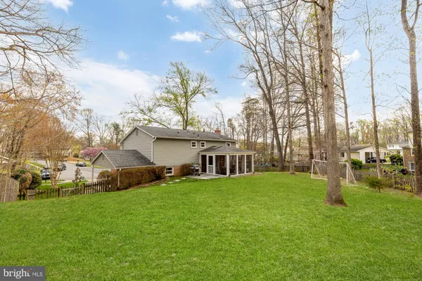 a view of a house with a big yard and large trees