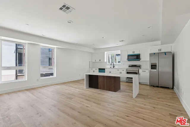 a kitchen with stainless steel appliances a refrigerator and a stove top oven