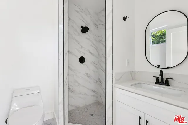 a bathroom with a sink a vanity and shower